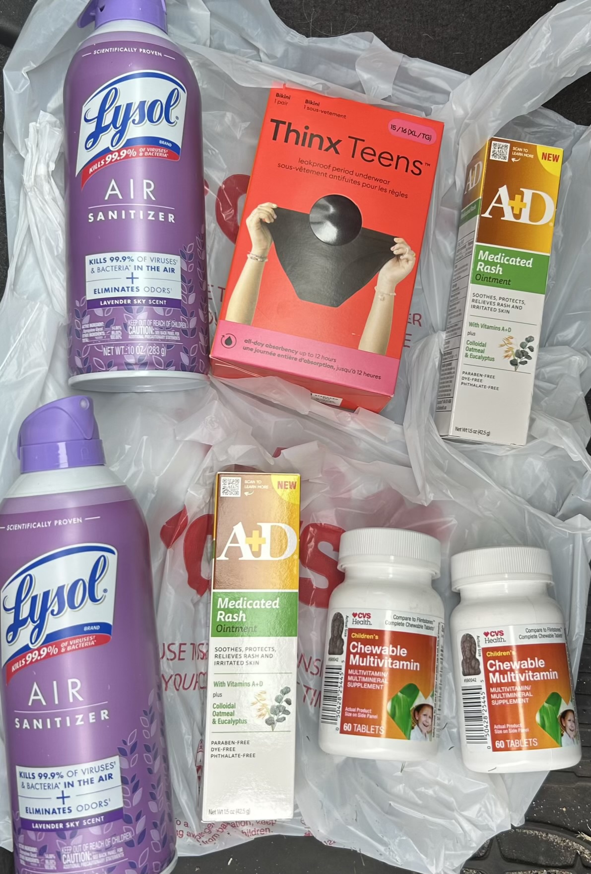 CVS shopping haul with Lysol air sanitizers, Thinx Teens underwear, A+D rash ointments, and CVS Health children’s chewable multivitamins.