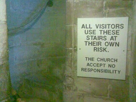 ancient church stairs with modern health & safety notice accepting no responsibility