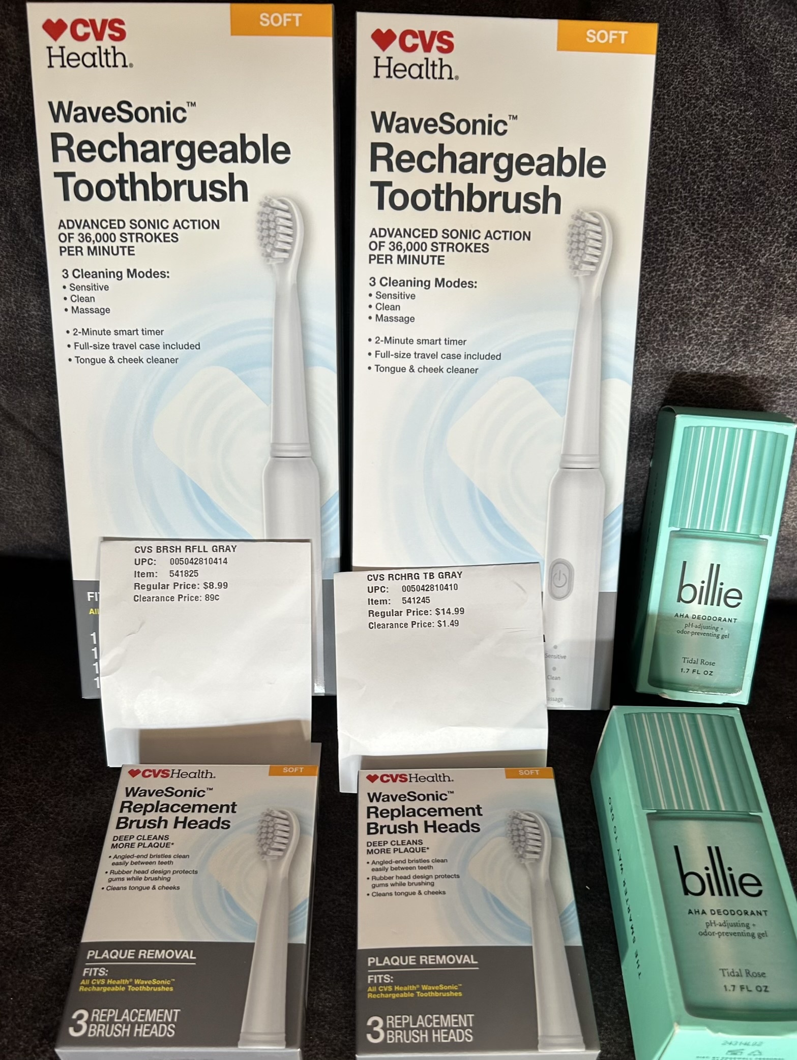Two CVS Health WaveSonic rechargeable toothbrushes and two packs of WaveSonic replacement brush heads displayed with CVS clearance labels showing prices as low as 89¢ and $1.49, alongside two Billie AHA deodorant sticks in Tidal Rose scent.