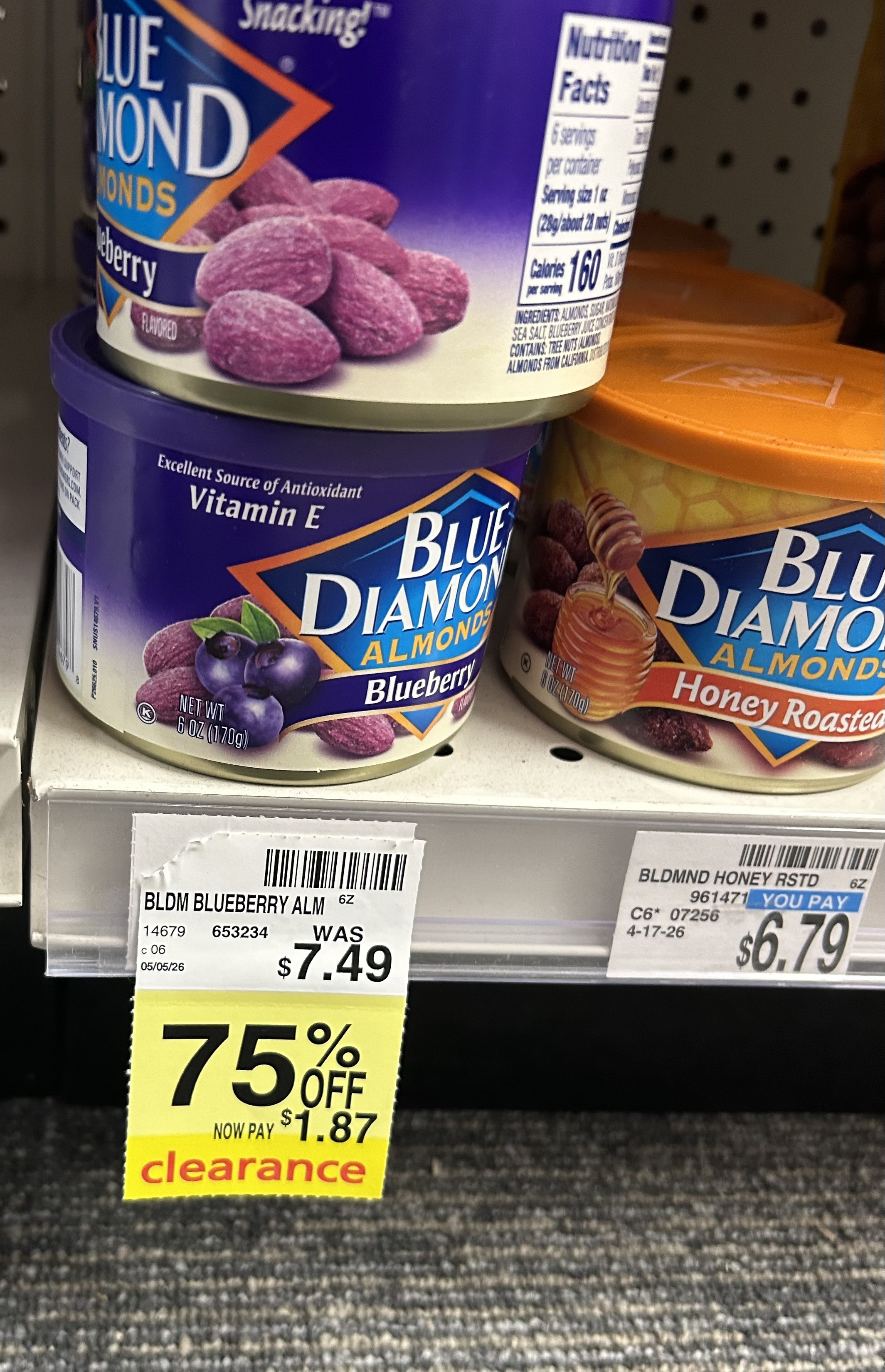 yellow clearance tag on a store shelf showing Blue Diamond blueberry almonds discounted 75% off, reduced from $7.49 to $1.87