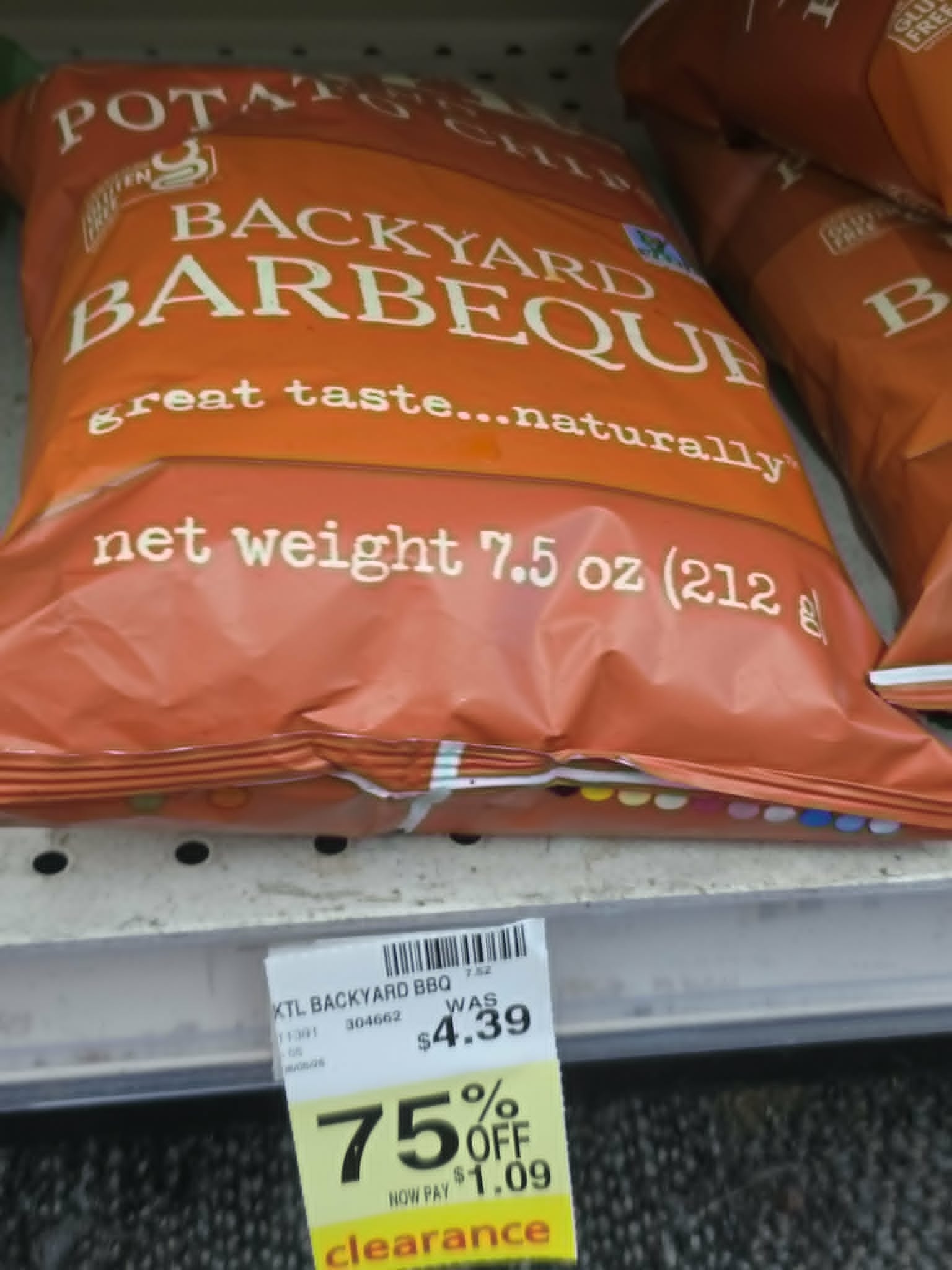 bag of backyard barbeque potato chips on a store shelf with a yellow clearance tag showing 75% off, reduced from $4.39 to $1.09
