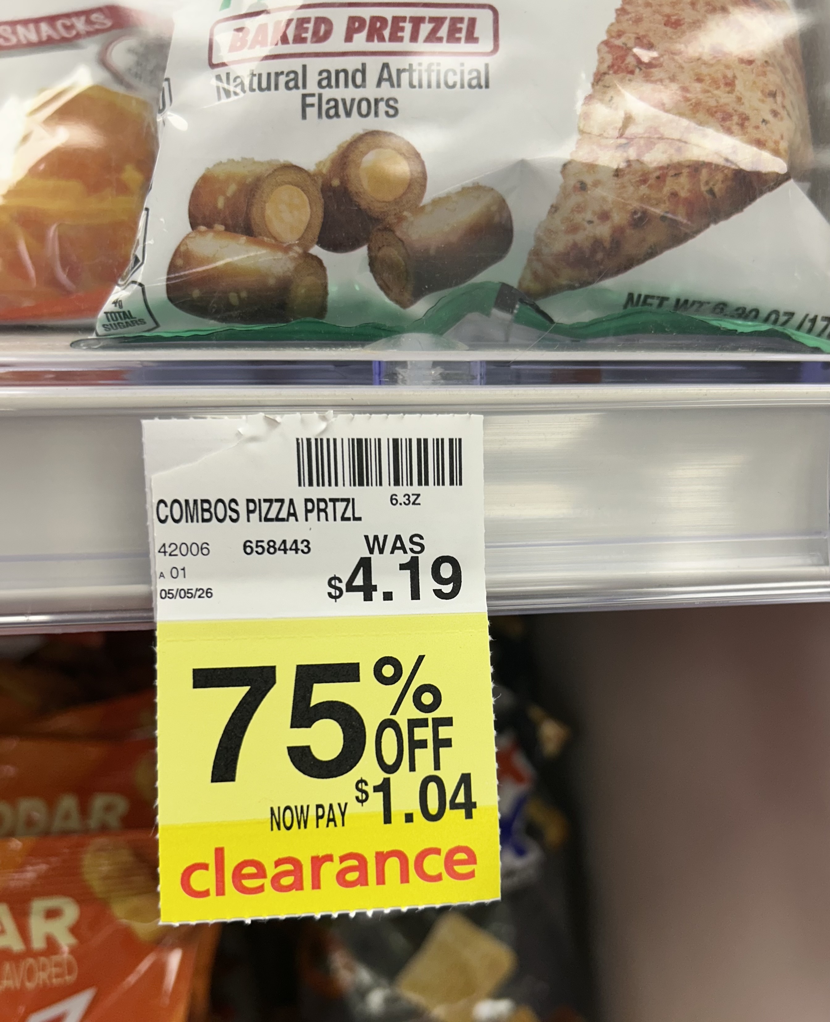 bag of Combos pizza baked pretzel snacks on a store shelf with a yellow clearance tag showing 75% off, reduced from $4.19 to $1.04