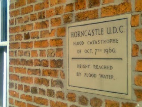 commemoration stone set at around head height, showing the level of the 1960 flood