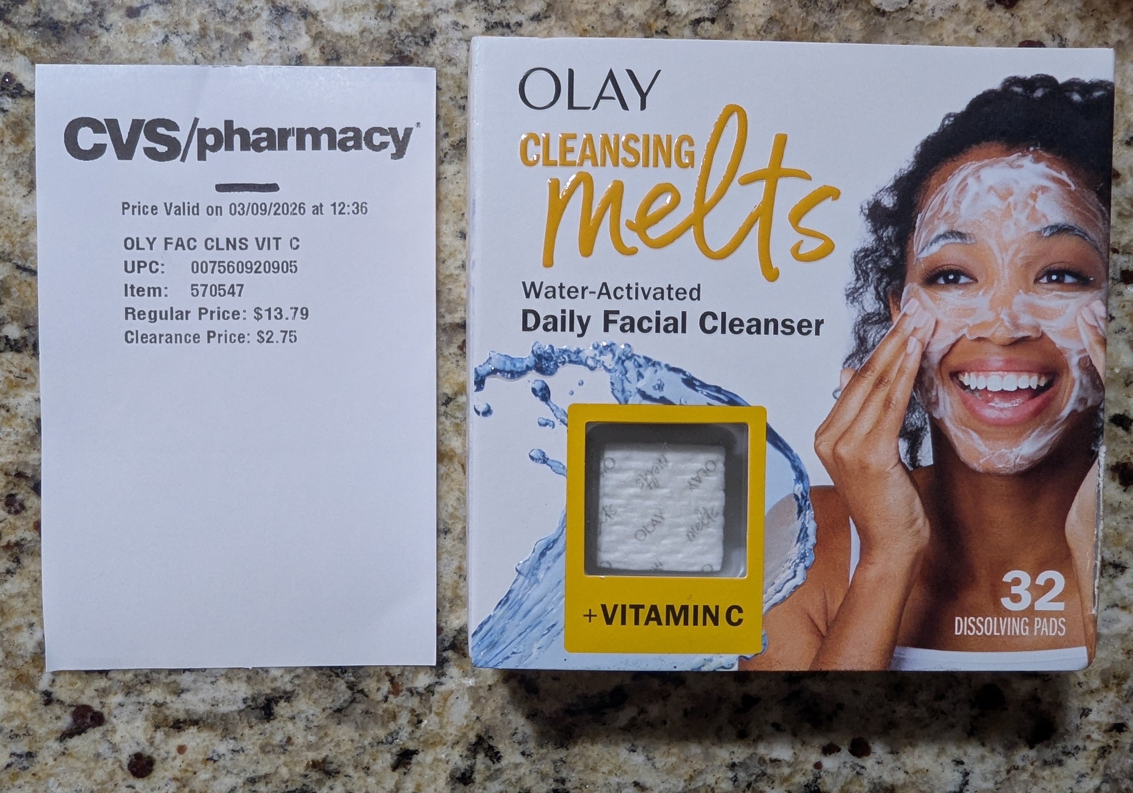 Olay Cleansing Melts water-activated daily facial cleanser with vitamin C (32 dissolving pads) next to a CVS/pharmacy clearance label showing the item reduced from $13.79 to $2.75, displayed on a granite countertop.