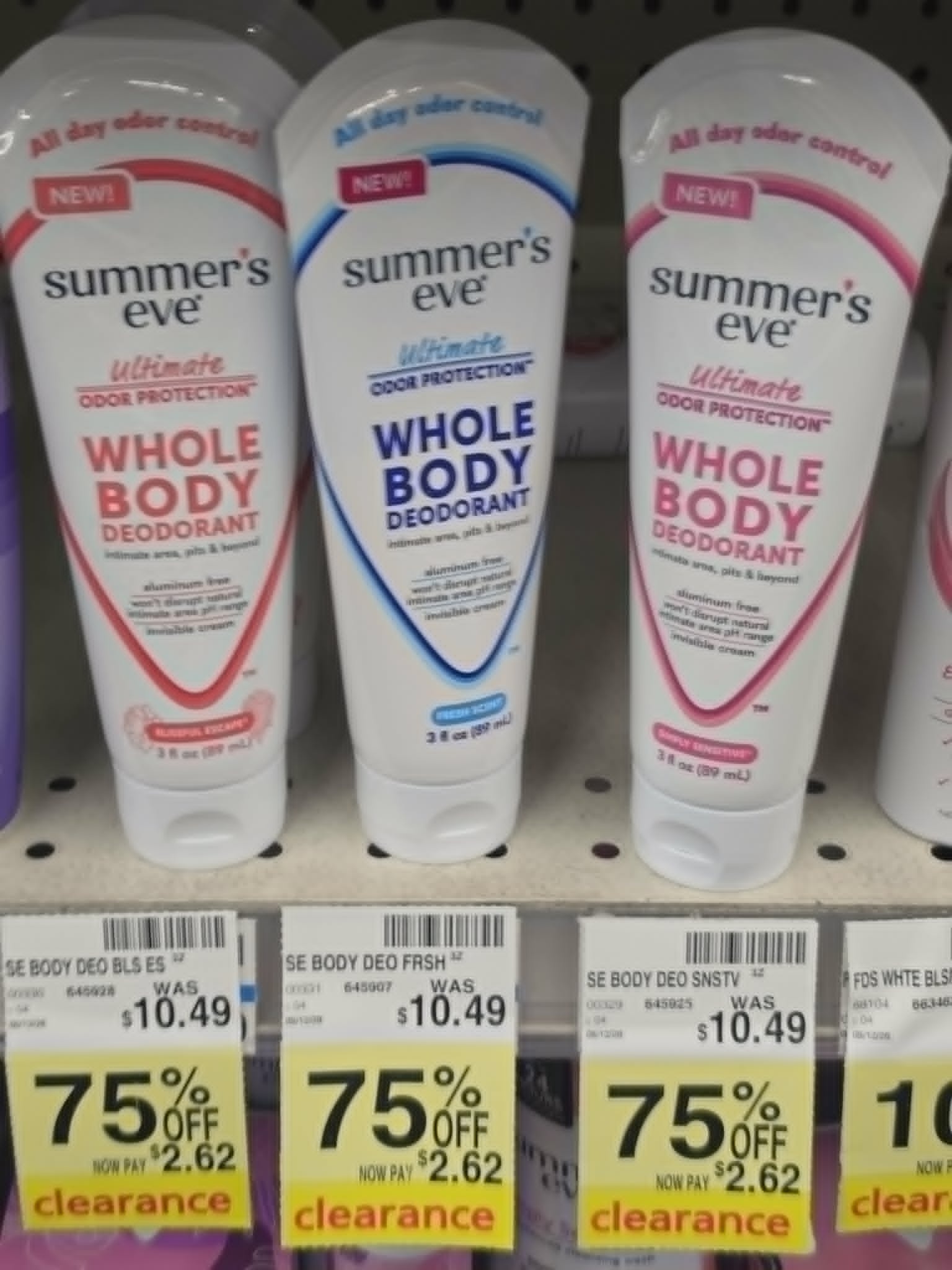 three tubes of Summer’s Eve whole body deodorant in different scents on a store shelf with yellow clearance tags showing 75% off, reduced from $10.49 to $2.62 each
